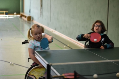 Zwei Mädchen im Rollstuhl, die Tischtennis üben